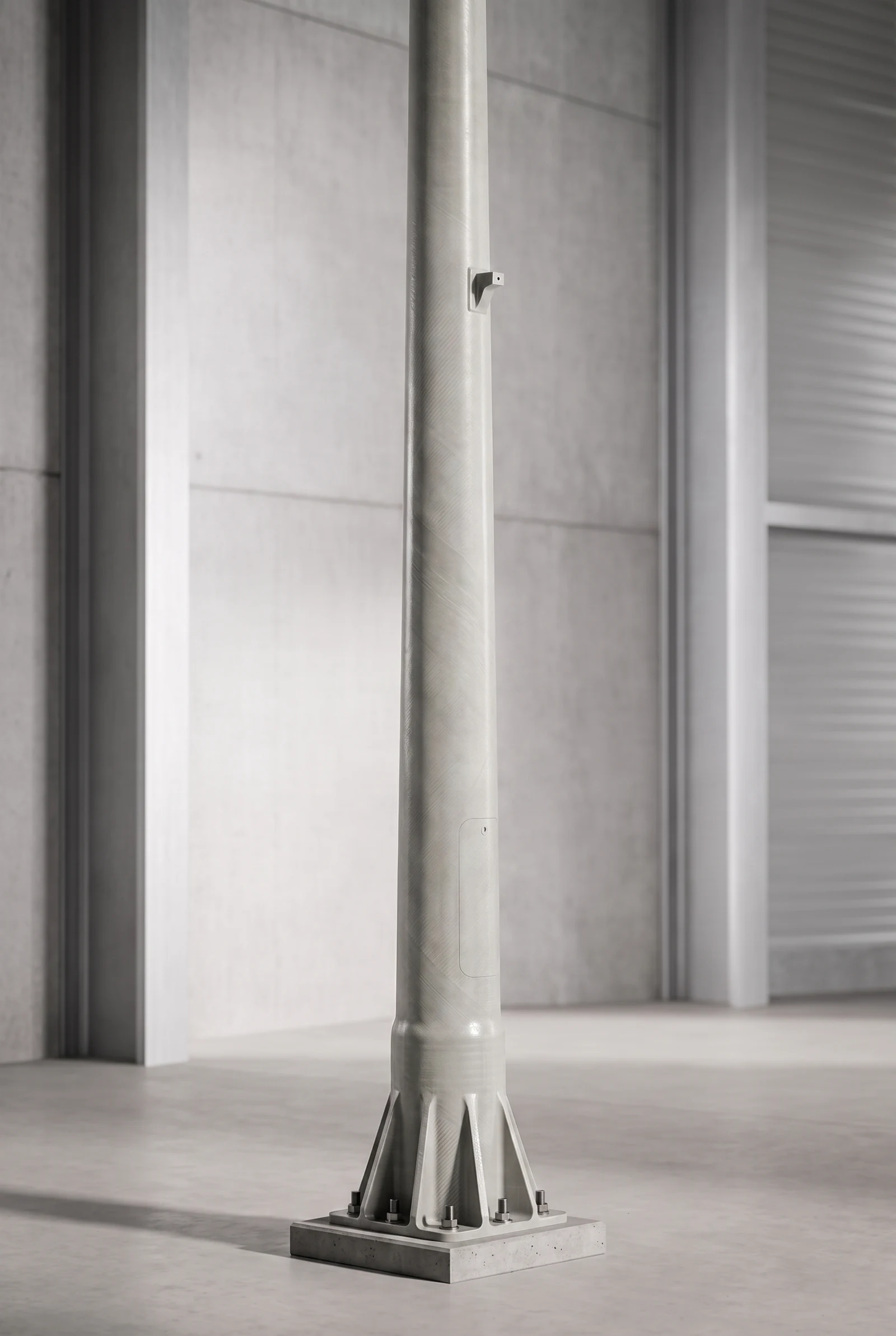Composite utility pole with a flanged base inside an industrial facility